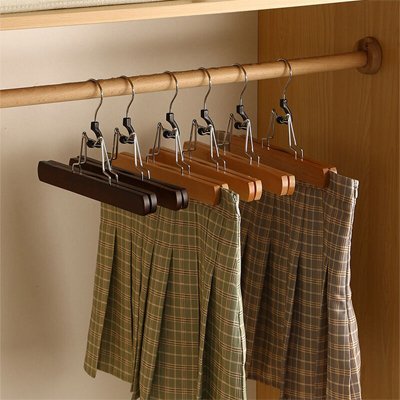 Cintre pantalon​ en bois gain de place suspendus dans garde-robe organisée avec pantalons et jupes